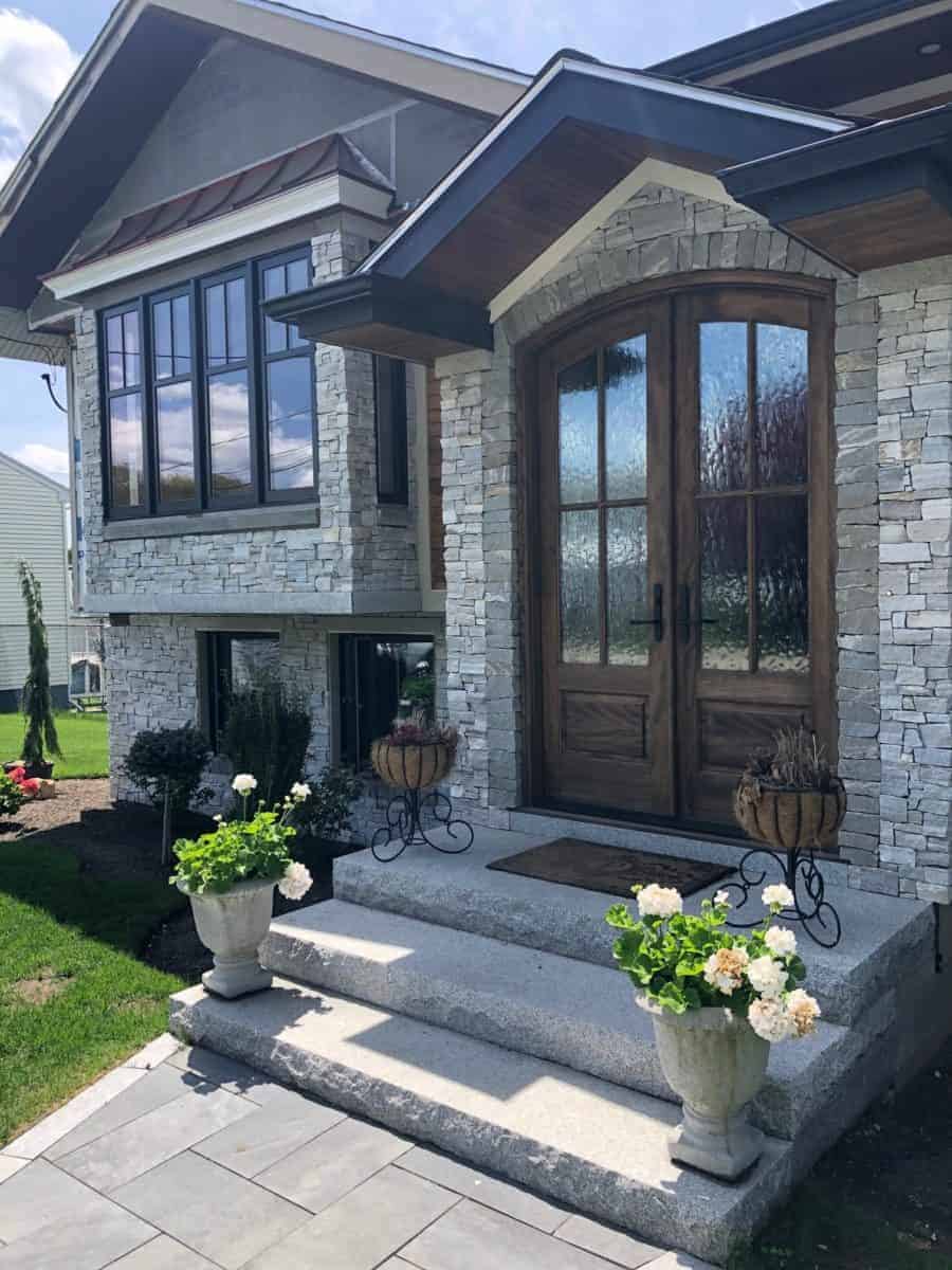 Traditional style home with stone exterior in natural stone veneer light colored stone porch