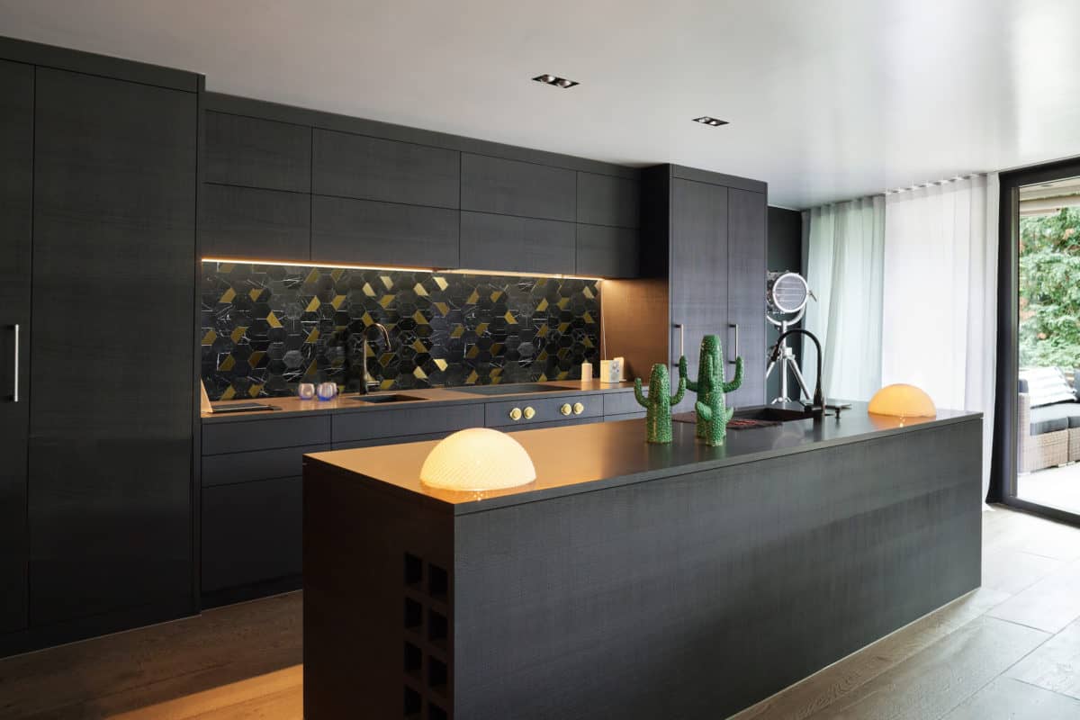 Black Marble and Brass Hexagon tile on a kitchen backsplash in an eclectic modern kitchen with gold kitchen hardware