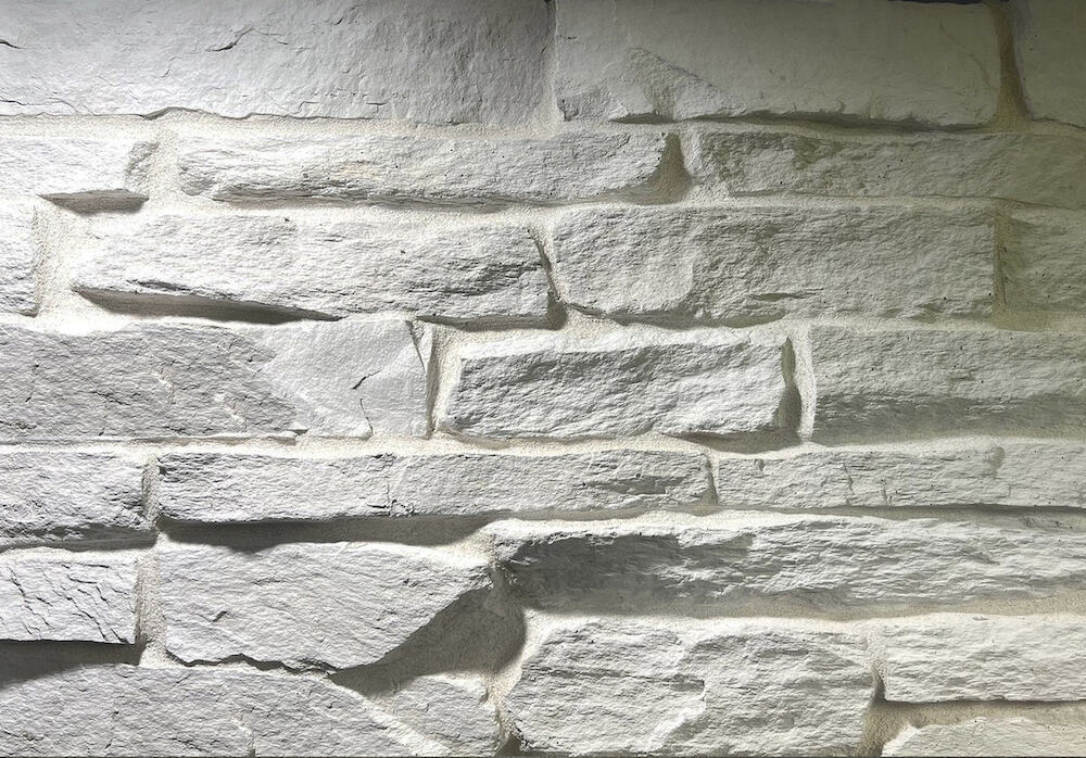 white long chiseled stone pieces mortared on a wall