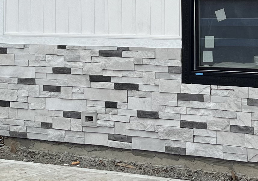 Single receptacle Faux Stone faux stone receptacle accessory trim on a home exterior