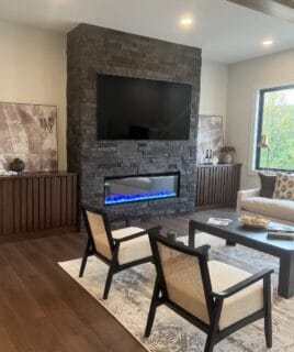 dark gray stone fireplace with no grout and a large tv