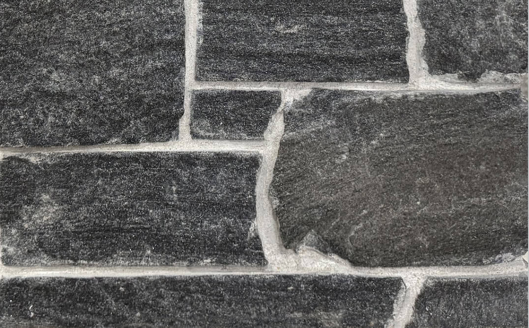 Sawn height loose stone Veneer in Black Granite with Mica sparkle and occasional Brown shading, split face with horizontal veining