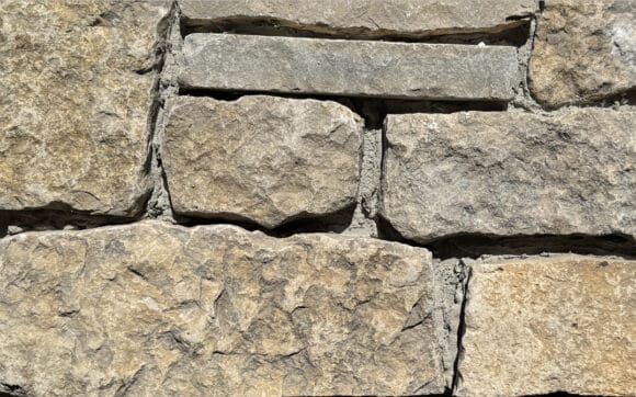 Stone veneer pieces of tumbled ledgestone and bed face stone made of Limestone in warm shades of tan