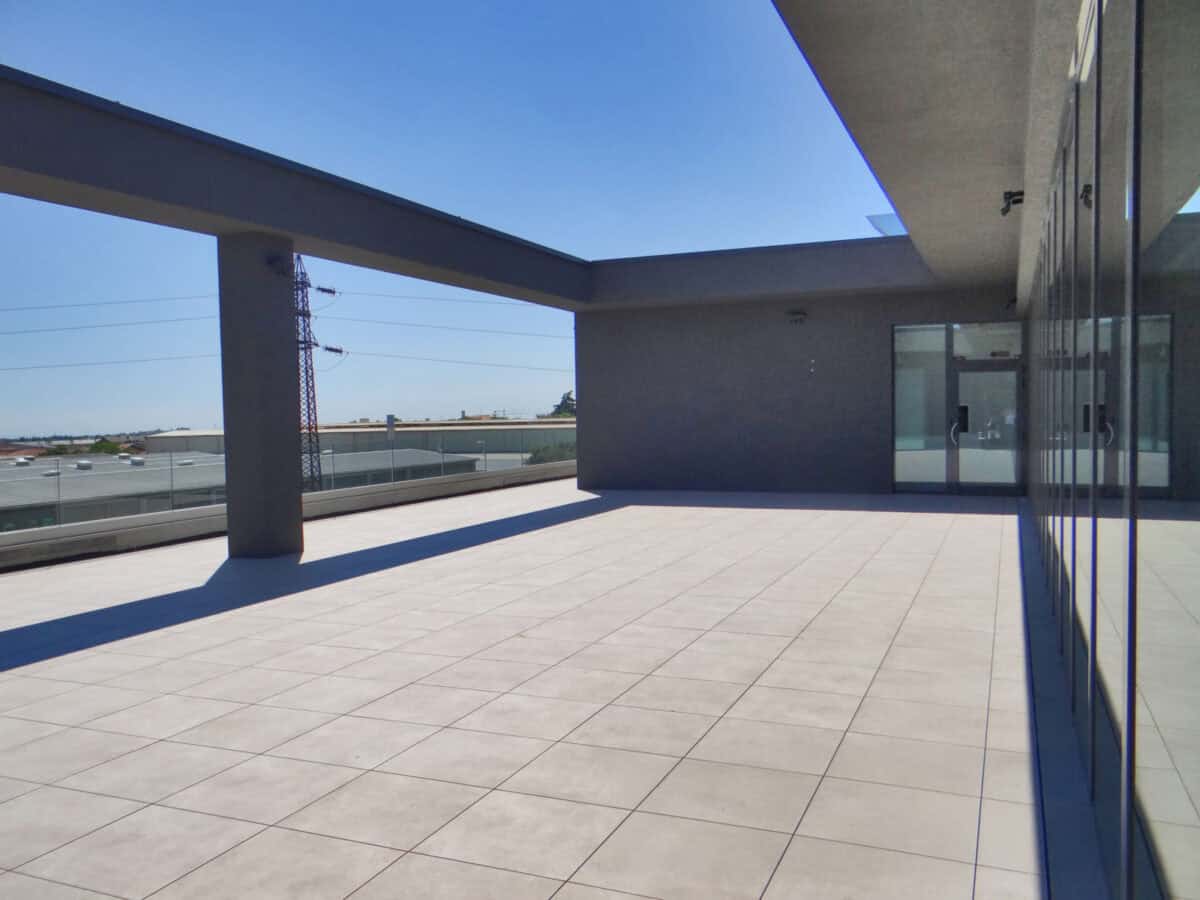 Light cream, beige concrete appearance for an outdoor porcelain paver used to finish a rooftop deck and terrace area