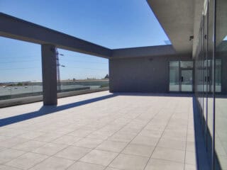 Light cream, beige concrete appearance for an outdoor porcelain paver used to finish a rooftop deck and terrace area