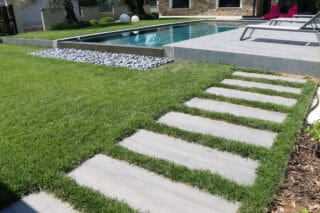 Darker wood looking outdoor porcelain pavers that are designed look like classic wood, while offering the properties of porcelain, set up for an outdoor patio and walkway