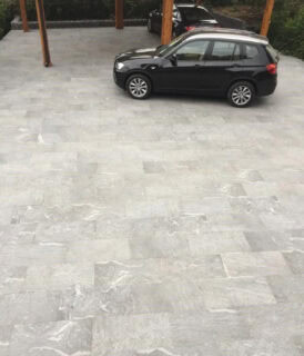 Heavily textured, gray to black outdoor porcelain pavers that have a premium look to a driveway set up.