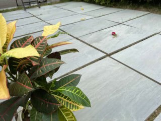 Light gray, outdoor porcelain pavers with a slightly textured surface laid out in a patio format