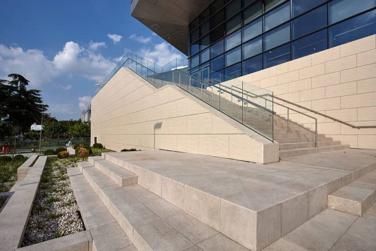 Light beige, cream colors outdoor porcelain pavers with embedded fossilized shells and stones throughout the surface designed for an outdoor area