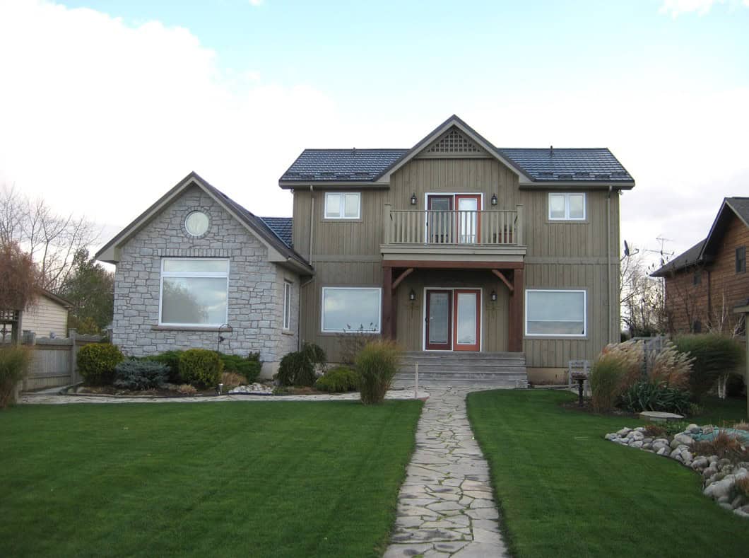 Tumbled finish loose stone limestone in shades of light grey, gold and blue-grey undertones on the exterior of a home