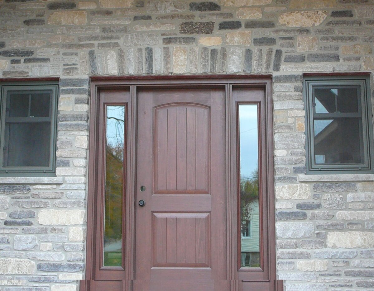 Split ledgestone face in Limestone in a blend of Brown, Grey, Tan, Black with horizontal veining set up for an entryway to a house