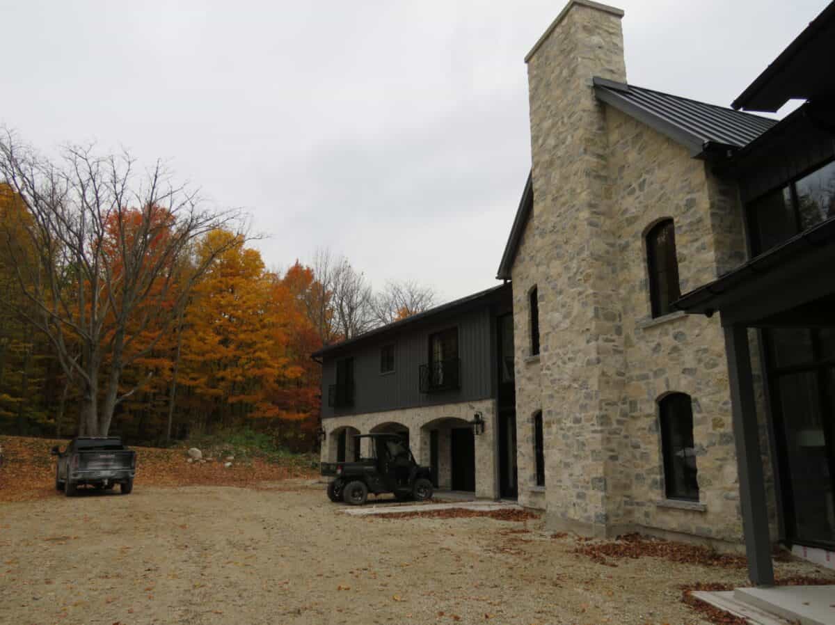 Tumbled finish loose stone limestone in shades of light grey, gold and blue-grey undertones and a reoccurring flat tan piece implemented in an outdoor wall