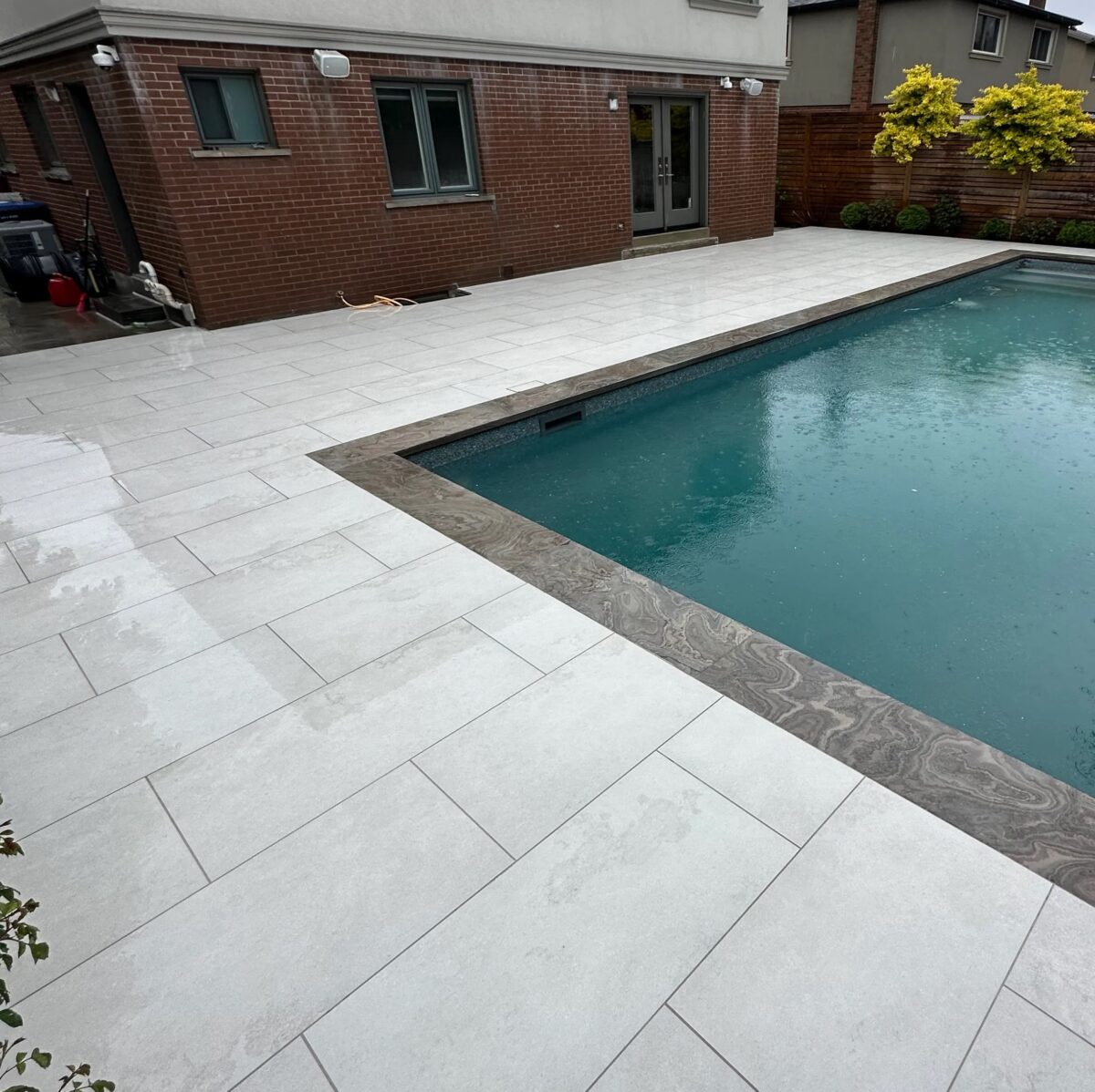 Cool, light gray white beige base with delicate veining, used to finish a pool deck area